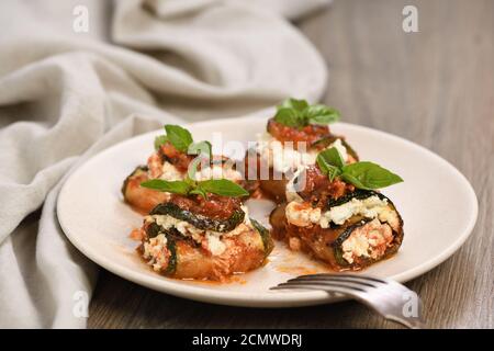 Gebackene Zucchini Brötchen gefüllt mit Ricotta und Basilikum unter Tomaten - Zwiebel - Sauce Stockfoto