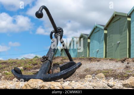 Foto des Ankers am Charmouth Beach mit Strandhütten Im Hintergrund Stockfoto