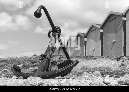 Foto des Ankers am Charmouth Beach mit Strandhütten Im Hintergrund Stockfoto