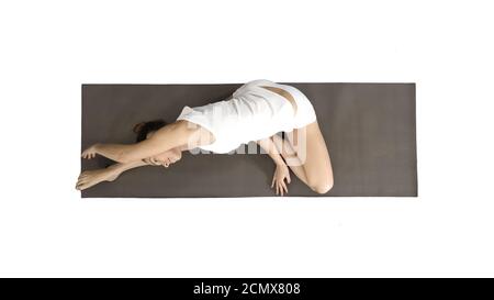 Schöne junge Frau trägt weiße Kleidung tun Yoga-Übung sitzen in einbeinigen King Pigeon (Single Pigeon) Pose auf weißem Hintergrund. Stockfoto