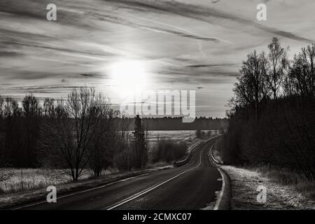 Schwarz-Weiß-Foto Landschafts-Straße bei Sonnenuntergang Stockfoto