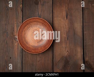 Leere braune Keramikplatten auf einem Holztisch Stockfoto