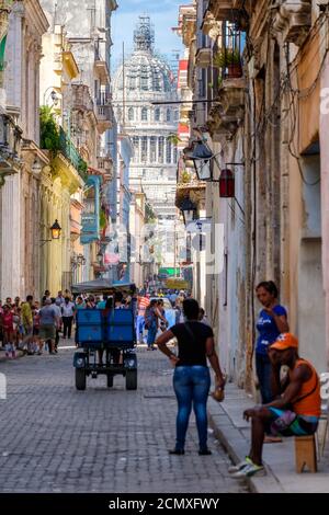 Bunte Nachbarschaft in der Altstadt von Havanna mit Blick auf die Kapitolgebäude am Ende einer engen Kopfsteinpflasterstraße Stockfoto