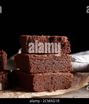 Stapel von gebackenen quadratische Stücke von Chocolate Brownie Kuchen auf braunem Holz Schneidebrett Stockfoto