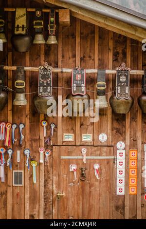 Kuhglocken und Auszeichnungen hängen auf einem Bauernhof in der Schweiz Alpen Stockfoto