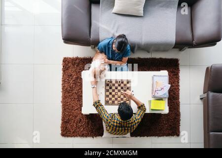 Junge Mann Und Frau Mit Spaß Mit Hund Beim Spielen Schach Stockfoto