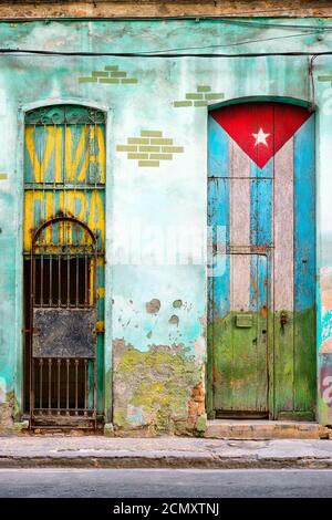 Altes Haus in Havanna mit einer kubanischen Flagge bemalt Seine Tür und die Worte Viva Cuba Stockfoto