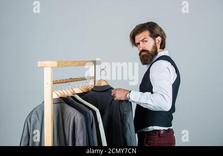 Mann bestellt Business Anzug posiert drinnen. Tailor Maßnahmen Mann. Stilvolle Mann am Arbeitsplatz. Modedesign-Studio. Modedesigner für Männer. Individuelle Maßnahmen Hand des Menschen. Gutes Feedback vom Kunden. Stockfoto