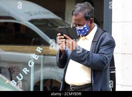 Ein Mann, der eine Gesichtsmaske als vorbeugende Maßnahme trägt, überprüft sein Telefon.mit den Befürchtungen einer "zweiten Welle" der Covid-19-Infektion, die sich abzeichnet, gewöhnen sich die Londoner an Präventivmaßnahmen in allen Aspekten ihres täglichen Lebens. In den letzten Tagen ist die tägliche Zahl der Coronavirus-Fälle wieder auf über 3,000 gestiegen. Stockfoto