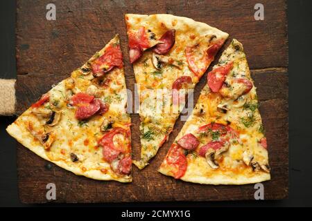 Gebackene Pizza mit geräucherten Würsten, Pilzen, Tomaten, Käse und Dill Stockfoto