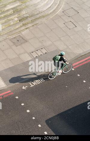 Radfahrer auf der Stadtbezirks-Hauptstraße Stockfoto