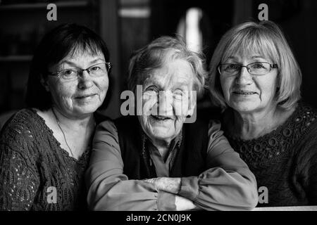 Eine alte Frau mit zwei erwachsenen Töchtern. Schwarzweiß-Fotografie. Stockfoto