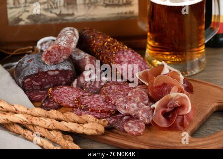 Antipasti Gericht mit Speck, Jerky, Salami, knusprige Grissini mit Käse. Ein Fleisch Vorspeise ist ein großer i Stockfoto