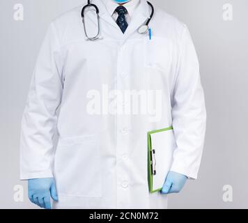 Arzt im weißen Mantel, blaue Latexhandschuhe, Stethoskop am Hals, Arzt mit einem Stockfoto