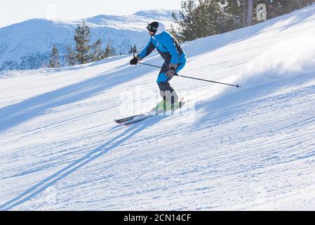 Skifahrer, die den Berg hinunterfahren Stockfoto