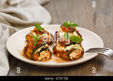 Gebackene Zucchini Brötchen gefüllt mit Ricotta und Basilikum unter Tomaten - Zwiebel - Sauce Stockfoto