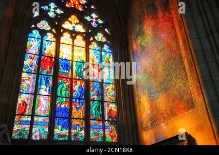 Helles Sonnenlicht, das in der 1344 n. Chr. gegründeten St. Veitskathedrale in Prag, Tschechien, durch Glasmalerei leuchtet Stockfoto