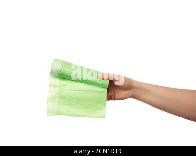 Weibliche Hand hält ein Bündel von grünen Plastiktüten für Müll Stockfoto