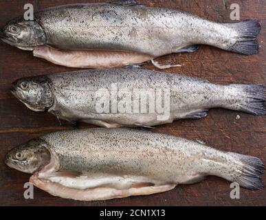 Frisch geschälte Forellenfische auf einem braunen Schneidebrett Stockfoto