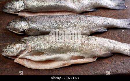 Frisch geschälte Forellenfische auf einem braunen Schneidebrett Stockfoto