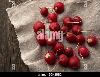 Rundes rotes Rettich liegt auf einer Vintage grauen Leinenserviette Stockfoto