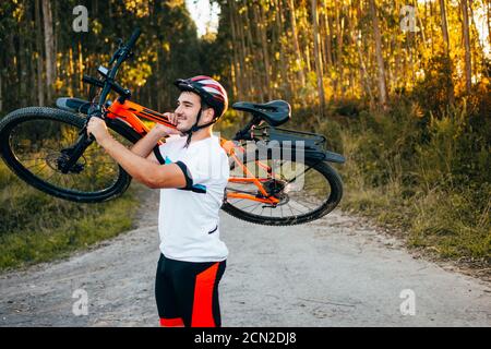 Mann mit Fahrrad auf Schulter Stockfoto
