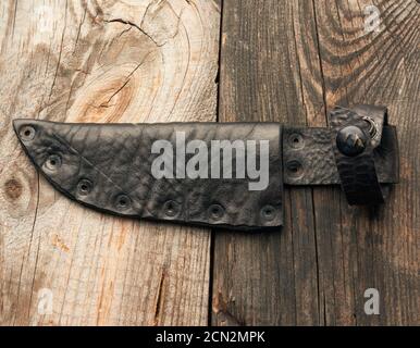 Lederetui für ein Messer liegt auf einem grauen Holz Hintergrund Stockfoto