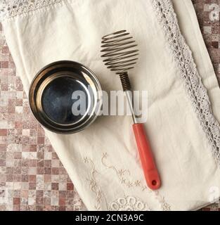 Vintage-Schneebesen zum Schlagen von Speisen und Eisenschüssel Stockfoto