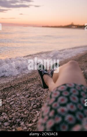 Nahaufnahme der Beine der Frau am Strand bei Sonnenuntergang Stockfoto