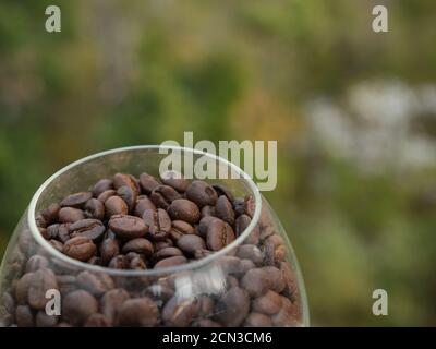 Nahaufnahme von gerösteten Kaffeebohnen in einem Glas mit Natur Hintergrund Stockfoto