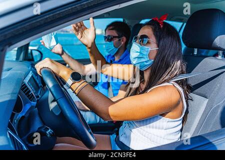 Ein Paar mit Gesichtsmask streitet, während sie ein Auto fährt In einem gefährlichen Stockfoto