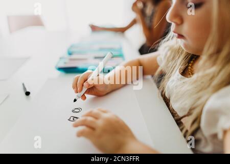 Nahaufnahme von jungen Mädchen Zeichnung Kreise mit Marker auf Papier Stockfoto