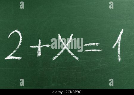 Knifflige mathematische Gleichung auf der grünen Schultafel. Handschrift einfache mathematische Gleichungen. Bildung und Lernen Stockfoto