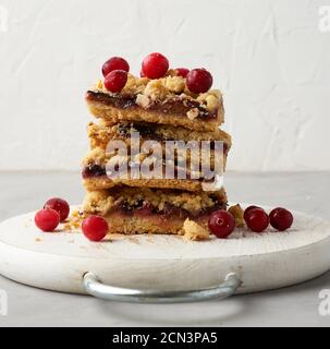 Stapel von quadratischen Scheiben von gebackenen Krümel Pie mit blau Pflaume auf einem weißen Holzbrett Stockfoto