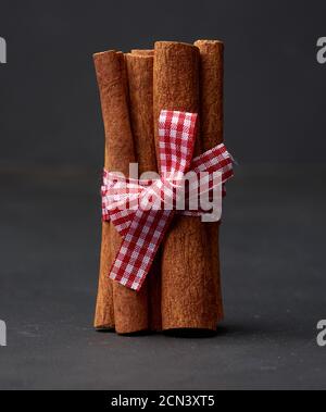 Band Bündel von braunen Zimt-Sticks auf einem dunklen Hintergrund Stockfoto