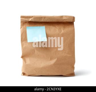 Volle Papier Einweg-Tasche aus braunem Kraftpapier mit einem Klebrige blaue leere Aufkleber isoliert auf weißem BA Stockfoto