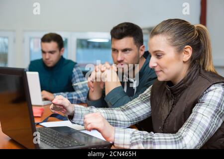 Lagerarbeiter und Manager betrachten Laptop in einem Lagerhaus Stockfoto