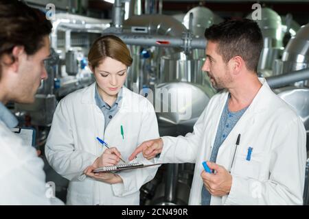 Fröhliche Mitarbeiterin mit weißem Laborkittel Stockfoto
