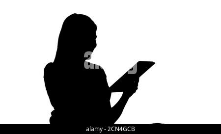 Silhouette Frau sitzt, tablet pc und lächelnd. Stockfoto