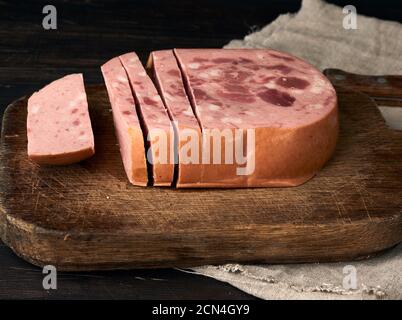In Scheiben geschnittene gekochte Wurst mit Scheiben von Vollfleisch auf einem Braunes Holzschneidebrett Stockfoto