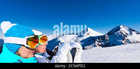 Zwei Erwachsene Skifahrerinnen stehen auf einem Berghintergrund Stockfoto