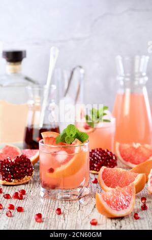 Tequila Cocktail mit Granatapfel und Grapefruitsaft, getönt mit dem Aroma eines frischen Zweig von mi Stockfoto