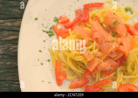 Lachs Spaghetti Mit Frischer Tomate Gegen Holztisch Stockfoto