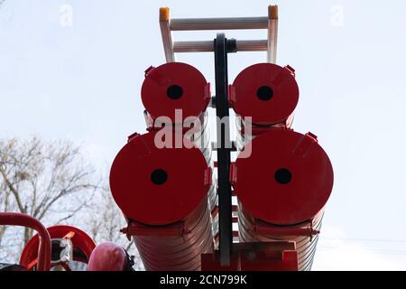 Ein Feuerwehrfahrzeug, Rückansicht von Kanistern für den Transport von Saugschläuchen mit an ihnen angebrachten Feuerlöschleitungen Stockfoto