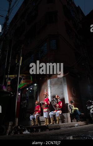 Drei indische Hochzeitsband-Musiker üben ihre tägliche Musikroutine am Abend auf der Straße in Kalkutta, Indien. Stockfoto