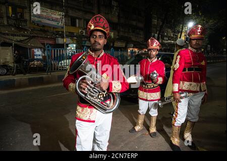 Drei indische Hochzeitsband-Musiker üben ihre tägliche Musikroutine am Abend auf der Straße in Kalkutta, Indien. Stockfoto