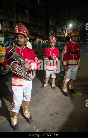 Drei indische Hochzeitsband-Musiker üben ihre tägliche Musikroutine am Abend auf der Straße in Kalkutta, Indien. Stockfoto