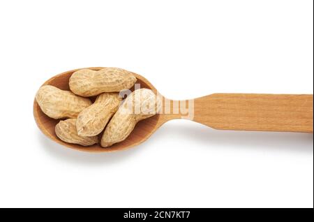 In Schale Erdnüsse liegt in einem Holzlöffel, leckere Früchte auf weißem Hintergrund isoliert Stockfoto