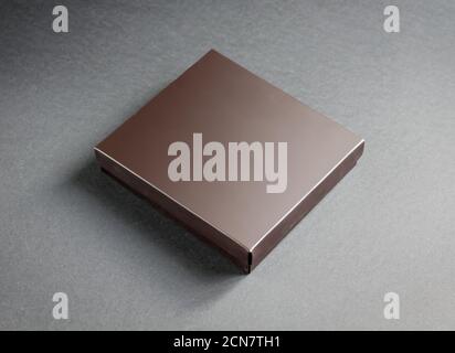 Schwarze Geschenkbox mit goldenem Band auf schwarzem Hintergrund