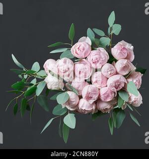 Schöner Blumenstrauß mit rosa Rosen und grünen Eukalyptusblättern. Stockfoto